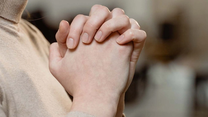 Woman clasping hands